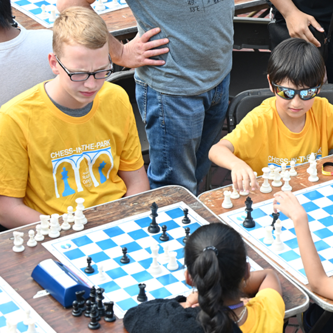 kids in custom gold chess shirts compete in the annual Chess in the Parks tournament on Bethesda Terrace, Central Park