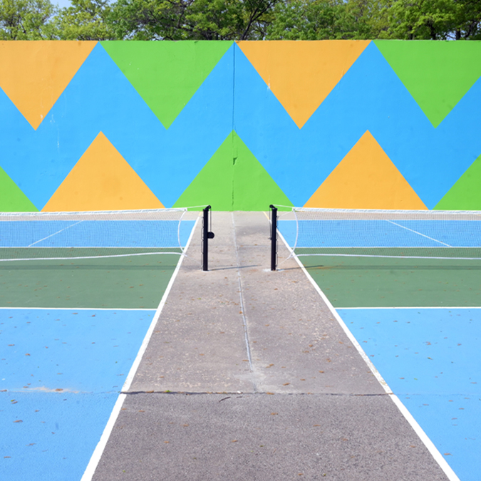 an underutilized wallball court was repainted to activate the space for adult fitness equipment and pickleball courts at Orchard Beach, Bronx